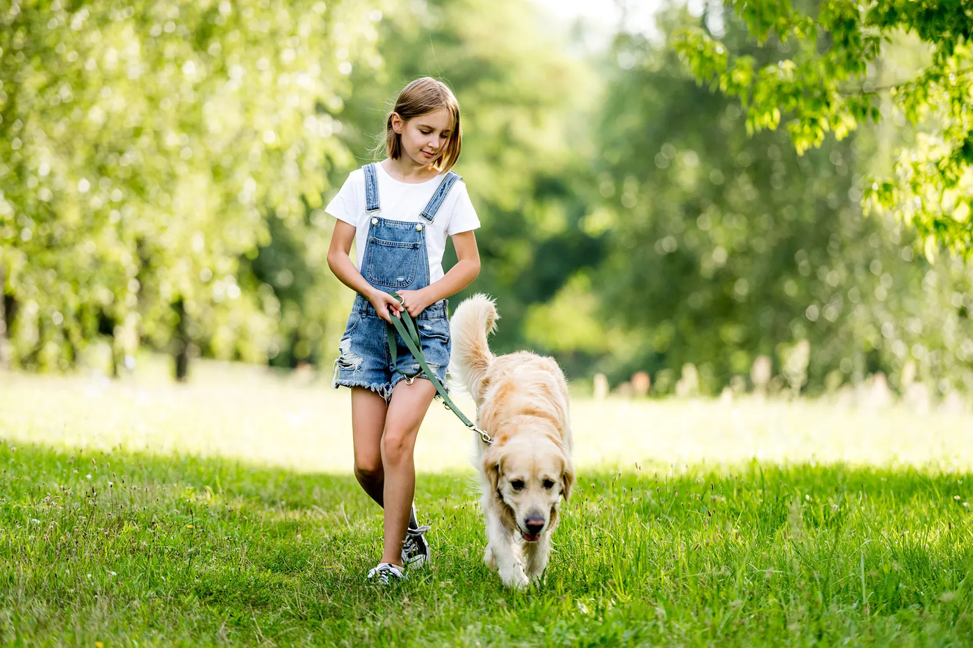 A little girl standing outdoors with her dog, the kind of child-and-dog pair seen on every Shadow Creek Ranch street