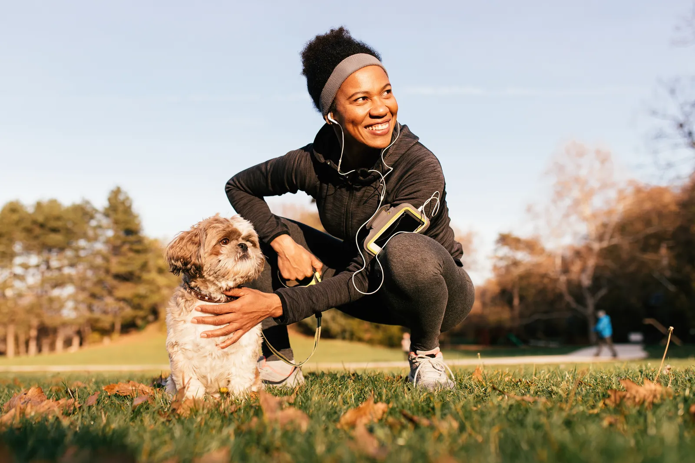 A woman in athletic clothes enjoying time outdoors with her dog, the active pairing Cross Creek Ranch trails are made for