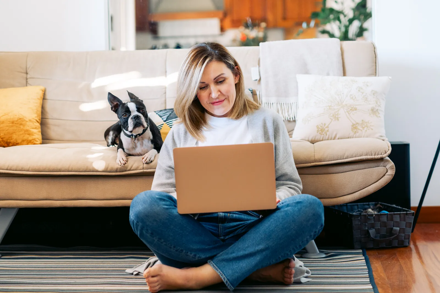 A young woman working from home with a Boston terrier beside her, the desk-hours routine done right